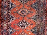 an orange and blue rug with a diamond design on it