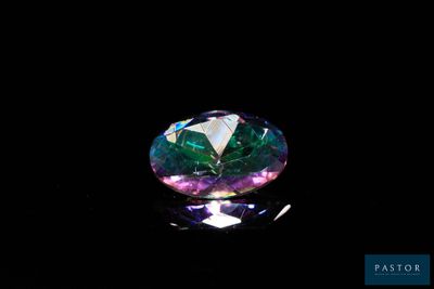un gros plan d'un diamant coloré sur une surface noire