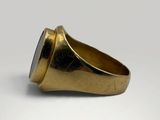 a close up of a gold ring with a black stone