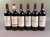 six bottles of wine are lined up in a row on a table