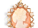 a close up of a woman ' s face with pearls in a broocher