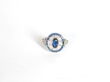 un gros plan d'une bague sertie d'un saphir bleu et d'une topaze blanche