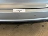 the rear end of a silver car with a sticker on it