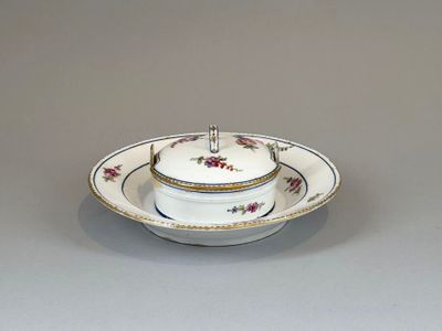 a white bowl and saucer sitting on a table