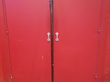 a red door with a metal handle and a black handle