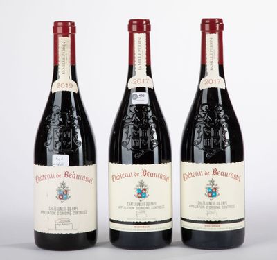 trois bouteilles de vin rouge posées côte à côte sur une table