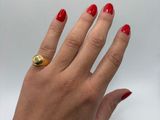 someone is holding a red manicured hand with a gold ring on it