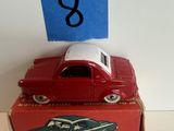 une petite voiture rouge posée sur une boîte rouge