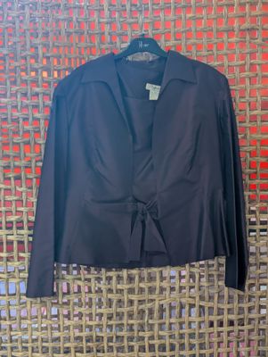 a black jacket hanging on a wall next to a red wall