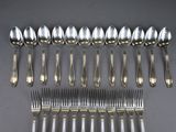 a lot of silver spoons and forks on the table
