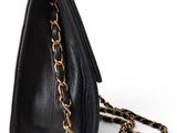 a black purse with a chain hanging from it ' s side