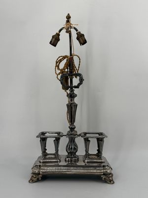 an antique silver plated candle holder with three candles on it
