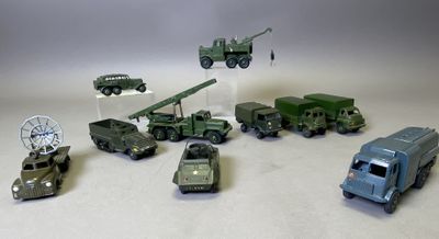 plusieurs véhicules militaires miniatures et une tour radio posés sur une surface blanche