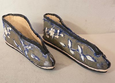 une paire de chaussons bleus et blancs ornés de fleurs