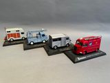 quatre camions miniatures alignés en vitrine