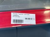 a label on the back of a red car that is for sale