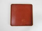 a close up of a red tray on a white surface