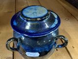 a blue glass jar sitting on a wooden table
