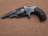 a close up of a revolver on a brown background