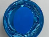 a blue glass bowl sitting on a white surface
