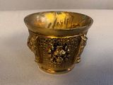 a gold cup that is sitting on a table