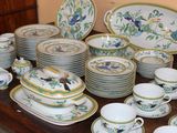 many plates and cups on a table with birds on them