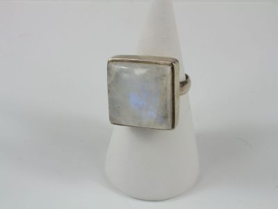 a close up of a ring with a white stone on it