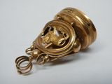 a gold object with a horse on it on a white surface