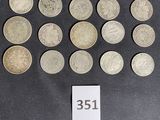 some silver coins are arranged in a circle on a black surface