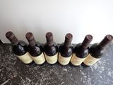 six bottles of wine are lined up in a row on a table