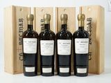 trois bouteilles de vin dans un coffret en bois sur une surface blanche