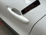 a sticker on the door handle of a white car