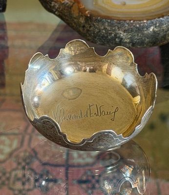 a silver bowl sitting on top of a glass table