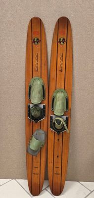 pair of skis sitting on top of a tiled floor next to a wall