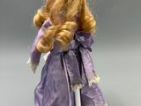 an image of a doll with blonde hair wearing a purple dress