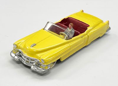 une petite voiture jaune avec un homme au volant et un autre sur la banquette arrière