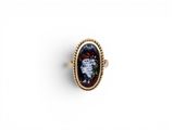 a gold ring with a black and red stone in the center