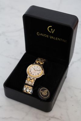 the watch is in a black box on a marble surface