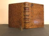 an old book sitting on top of a table next to a white wall