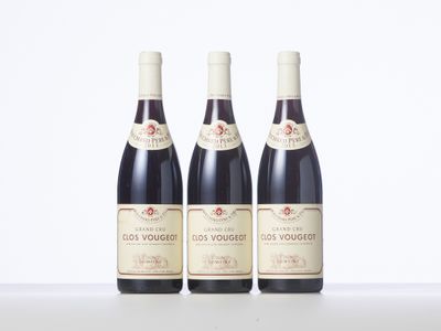 three bottles of red wine sitting on top of a table