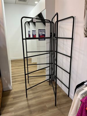un portant avec des vêtements, dans un coin de la pièce