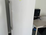 two white refrigerators sitting next to each other in a room