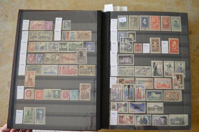 une personne tenant un livre sur lequel figurent des timbres