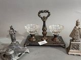 trois figurines en argent et un bougeoir en argent posés sur une table