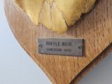 a heart shaped piece of cheese on a wooden board