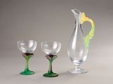 three wine glasses and a pitcher sitting next to each other