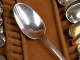 several spoons and spoon rest on a table with a brown cloth