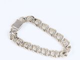 a close up of a silver chain bracelet on a white background