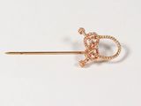 a close up of a gold pin with a knot on it