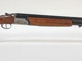 un gros plan d'un fusil posé sur un support transparent, sur une surface blanche
